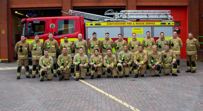 Group of firefighters gathered in front of engine